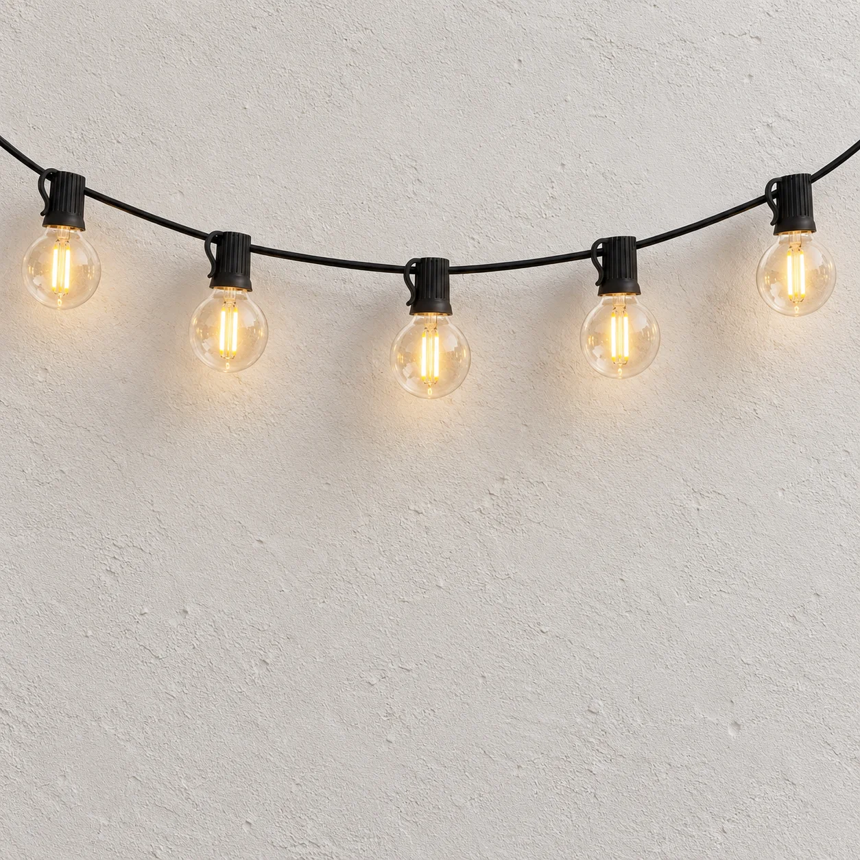 Jude solar string lights hanging against a plain off-white wall; partial string shown